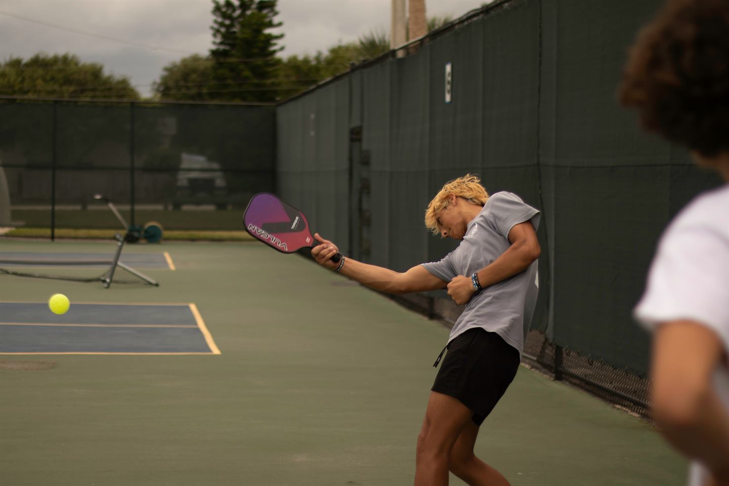 Player mid-swing on an outdoor court